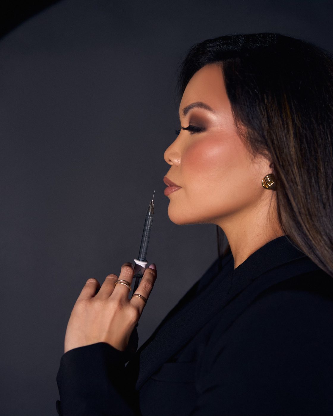 Lecille Desamparado in profile, holding a syringe