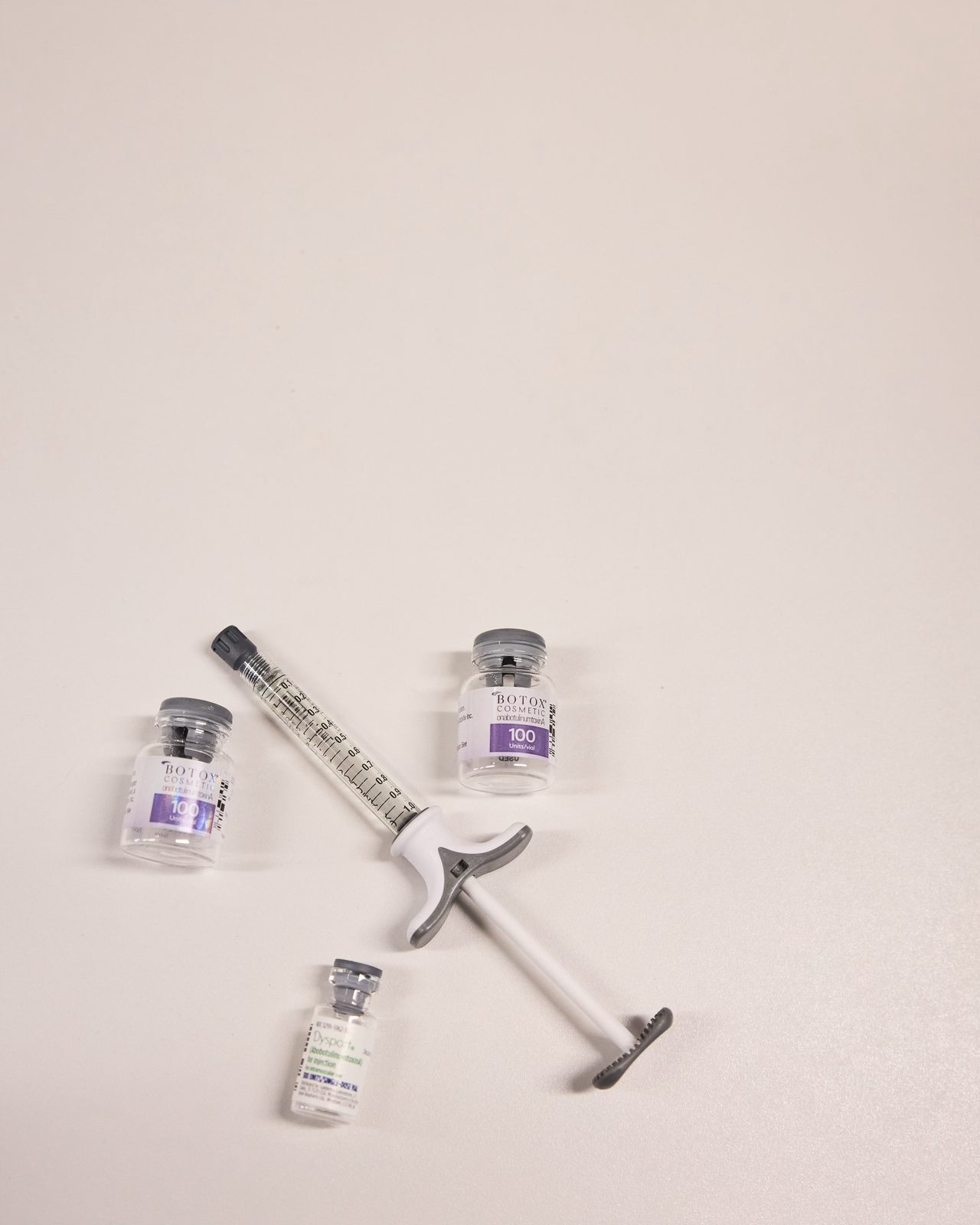 Botox Cosmetic and Dysport vials beside a syringe